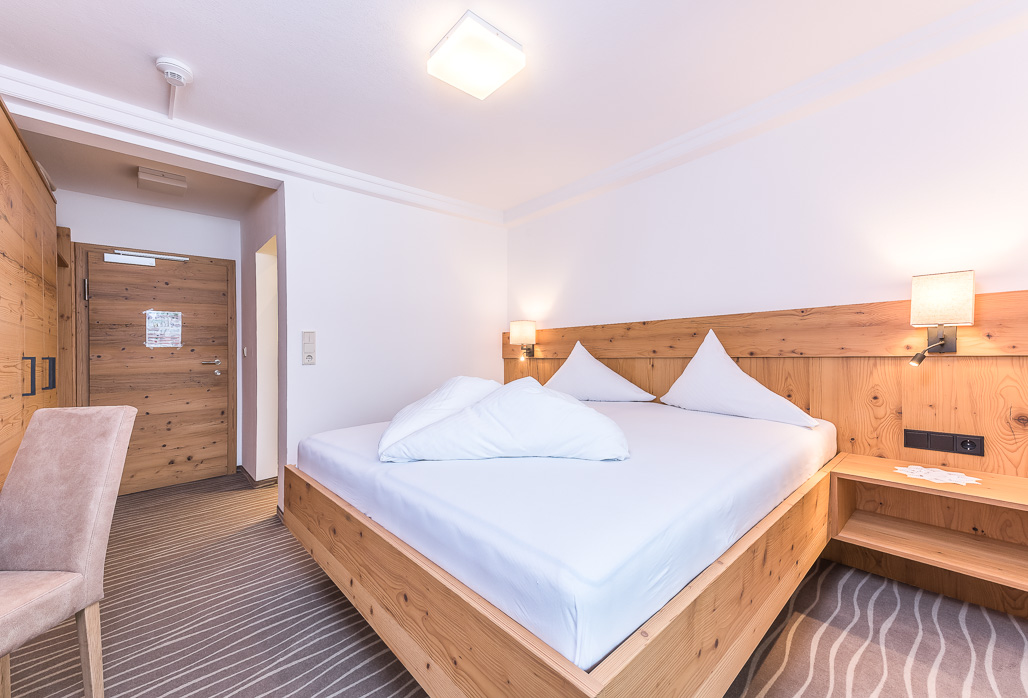 Doppelzimmer mit Holzbett und warmem Licht